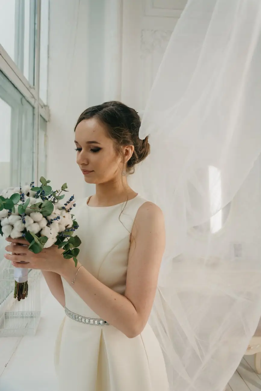 woman in white sleeveless gown holding white flower bouquet infront of window